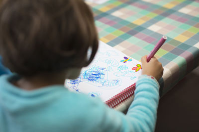 Midsection of child on paper