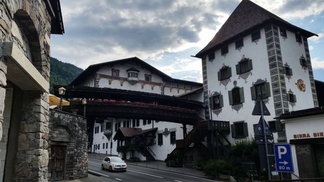 CARS ON ROAD BY BUILDINGS IN CITY AGAINST SKY