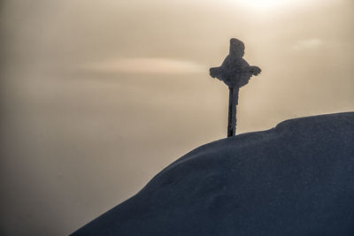 Snowcapped mountain cross in the sunset