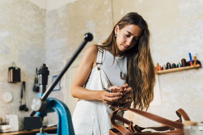 Fashion designer making leather accessory at workshop