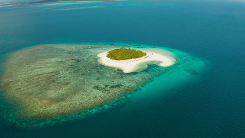 Sandy beach and tropical island by atoll with coral reef and axure water, top view. patawan island 