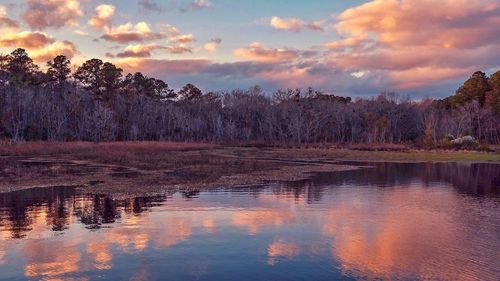 Scenic view of lake against sky at sunset