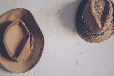 Two hats on a rustic concrete wall 