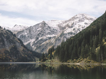 Scenic view of lake by mountains against sky