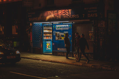 Man on illuminated city street at night