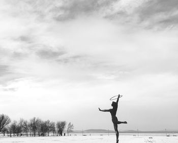 Man on tree by sea against sky