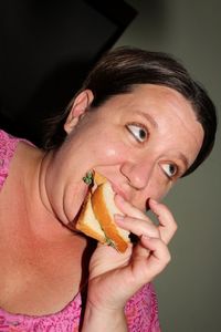 Tilt shot of woman eating sandwich at home