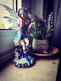 Young woman sitting by potted plant on table