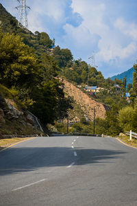 Empty road by mountain against sky