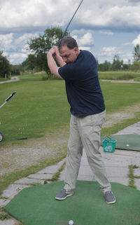 Full length of man playing golf on field