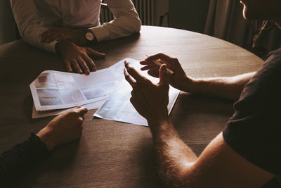 High angle view of people sitting on paper at home