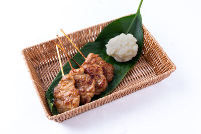 High angle view of meat and leaves on white background