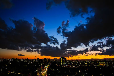 Silhouette buildings against sky at night