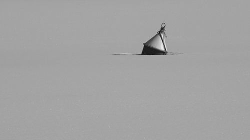 Buoy in frozen lake during winter