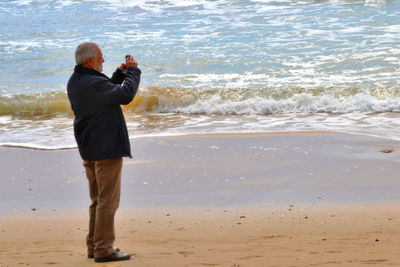 Rear view of man standing on beach