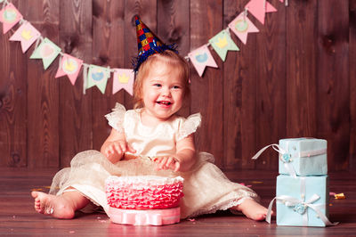 Happy cute baby girl playing with cake