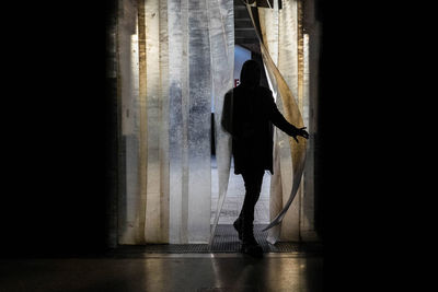 Rear view of silhouette man standing in corridor