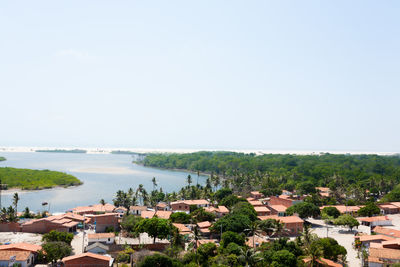 High angle view of buildings and sea against clear sky