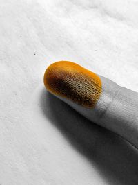 Close-up of hand on orange table