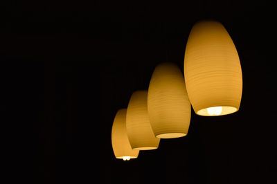 Illuminated lighting equipment hanging against black background