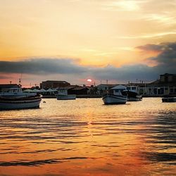 Boats in sea at sunset