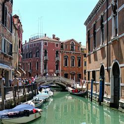 Boats in canal along buildings