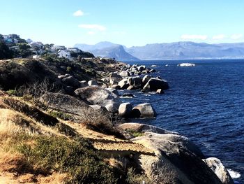 Scenic view of sea and mountains against sky