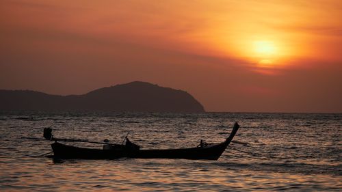 Silhouette boat in sea against sky during sunset