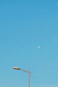 Low angle view of street light against blue sky