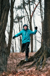 Low angle view of young man running in forest
