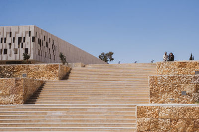 Low angle view of staircase against clear blue sky