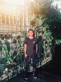 Portrait of young man standing against plants