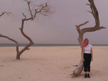 Full length of man standing on tree at beach