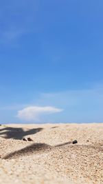 Surface level of beach against blue sky