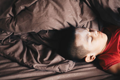 High angle view of girl sleeping on bed at home