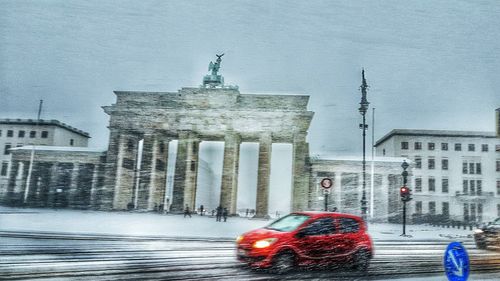 Cars in illuminated city against sky