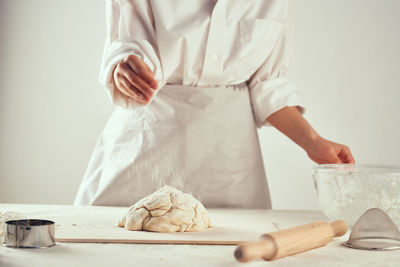 Midsection of person holding ice cream on table