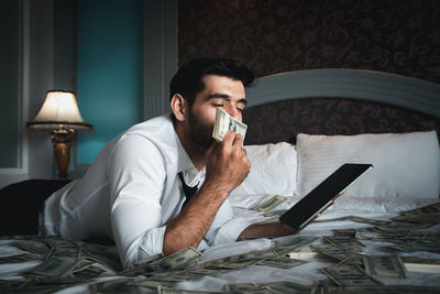 Man using mobile phone while sitting on bed