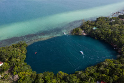 Aerial view at cenote del la bruja with vessels on it at coastline of mexico on a sunny day