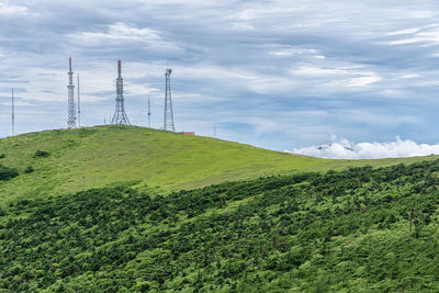 Electricity pylon on field against sky