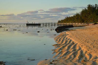 Scenic view of beach against sky during sunset