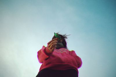 Low angle view of person flying against sky