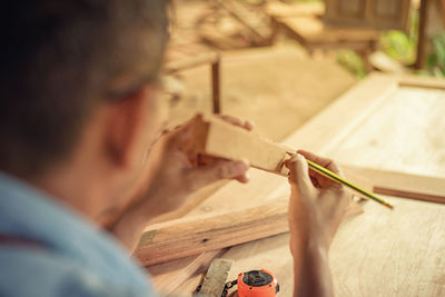 Rear view of man working on wood