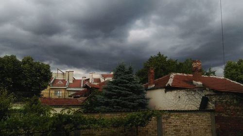Houses against cloudy sky