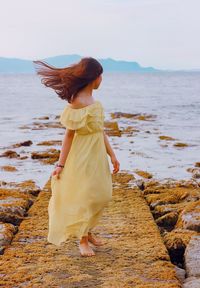 Woman on beach against sky