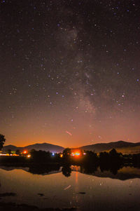Scenic view of lake against sky at night