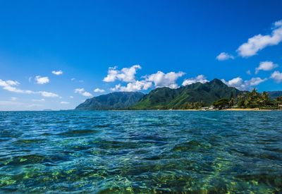 Scenic view of sea and mountains against sky