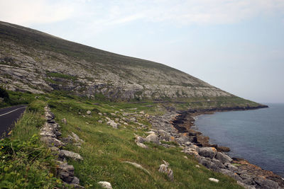 Scenic view of sea and mountains against sky