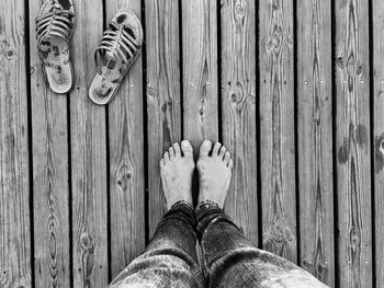 Low section of man standing on boardwalk