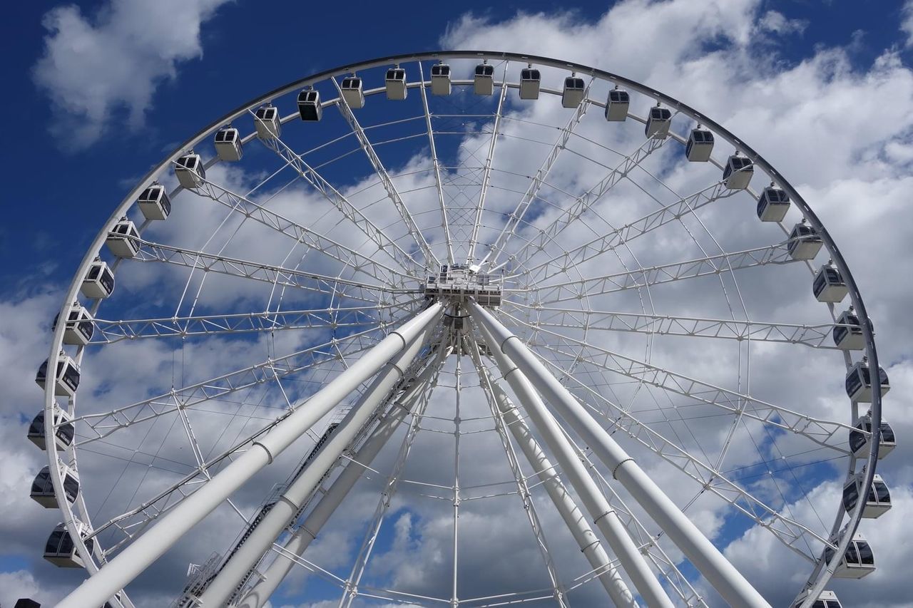 LOW ANGLE VIEW OF FERRIS WHEEL AGAINST CLOUDY SKY